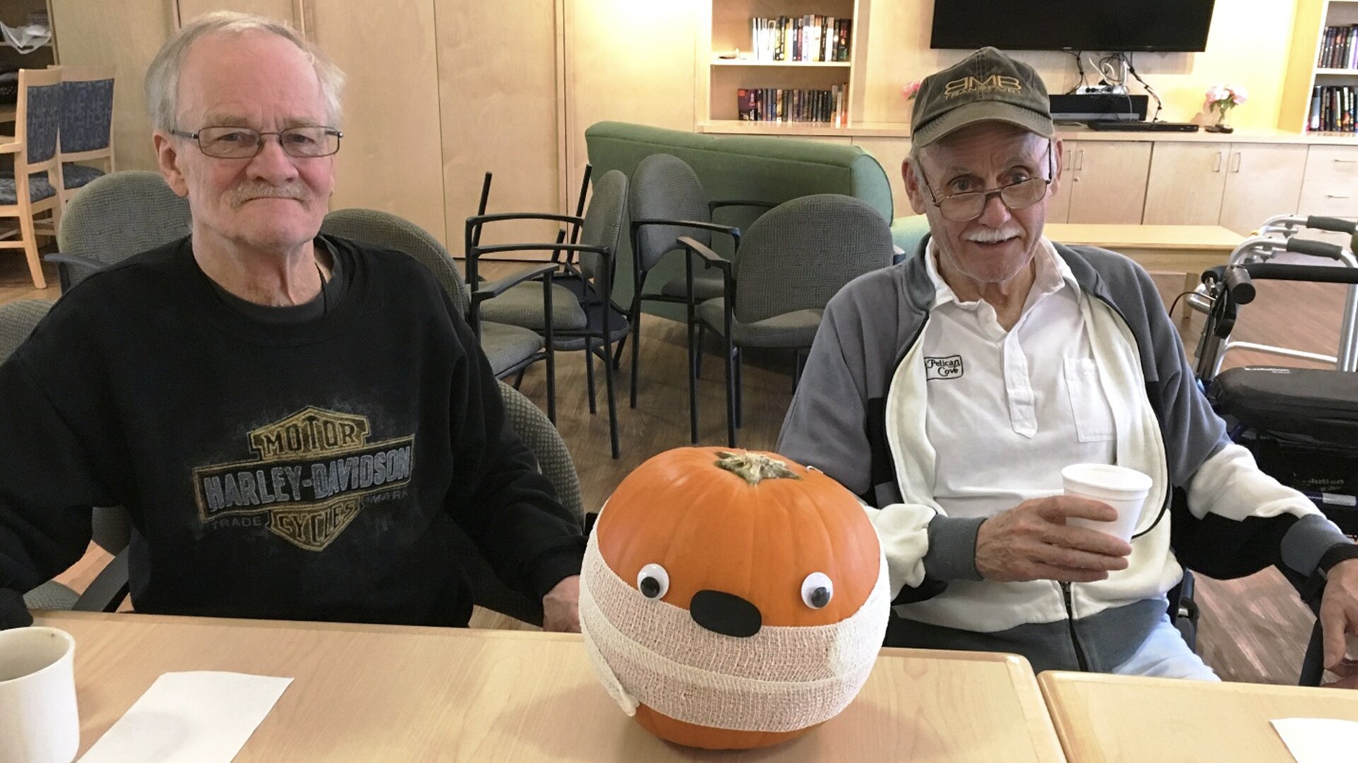 Two elderly man participating in pumpkin decoration event at Sagebrush